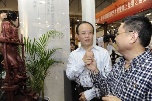 文化部副部长丁伟（左）参观泉州馆，与木雕大师郑国明交流